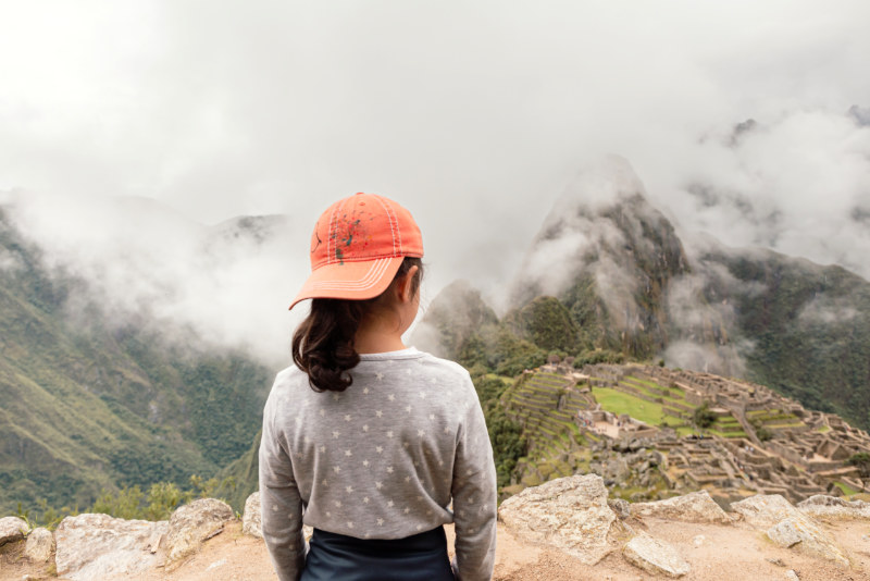 Girl admiring the archaeological site of Machu Picchu