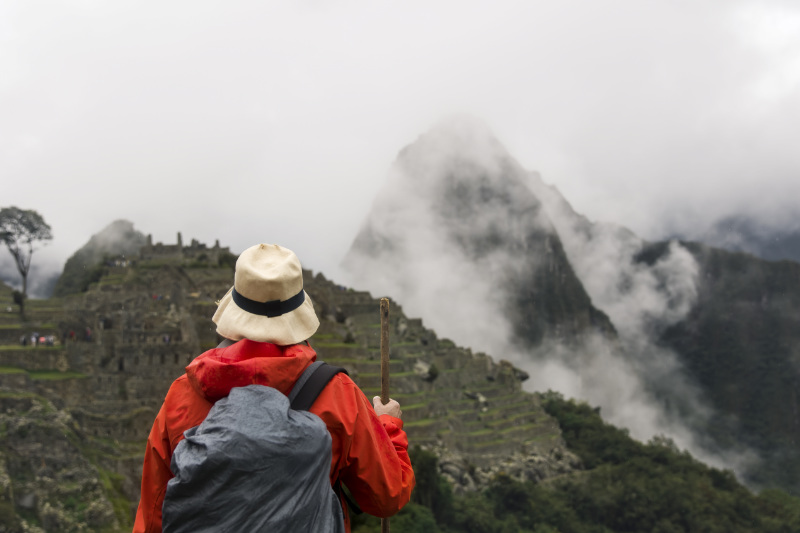 Tourist exploring Machu Picchu on a cloudy day