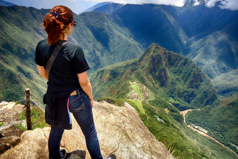 Tourist observing the Inca citadel from the top of Machupicchu Mountain